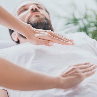 Reiki therapy on reclining individual
