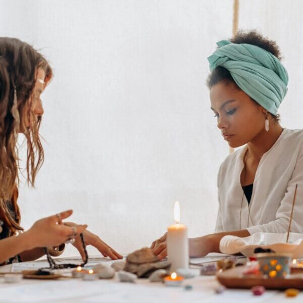 Two women engaged in a tarot card reading at a cozy table.